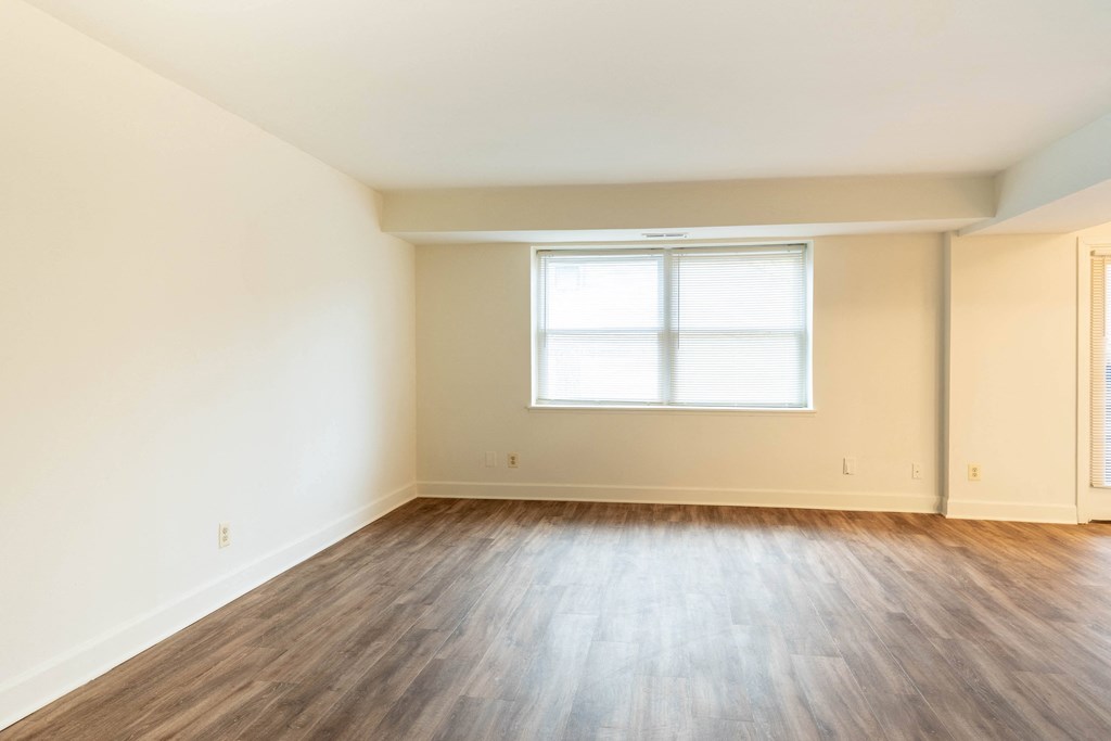 a bedroom with hardwood floors and a window  at Charlesgate Apartments, Towson, Maryland