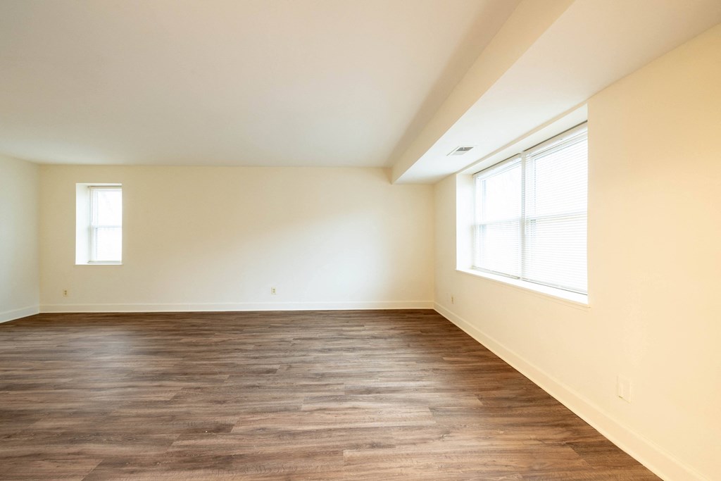 a bedroom with hardwood flooring and two windows  at Charlesgate Apartments, Towson, 21204