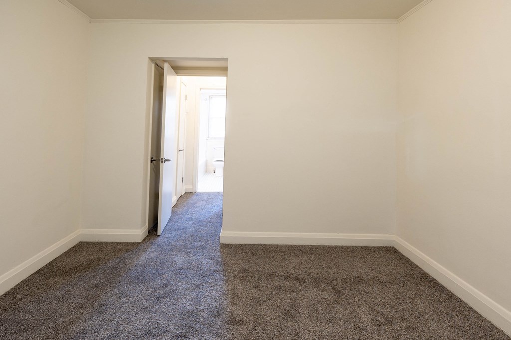 a bedroom with a carpeted floor and white walls at Loch Bend Apartments, Baltimore, 21234