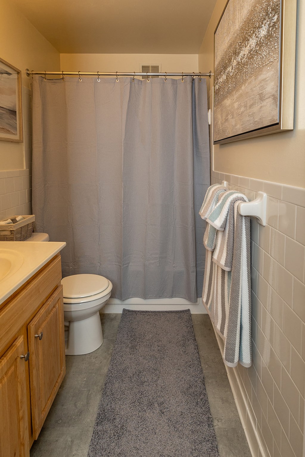 A bathroom with a toilet, sink, and a chandelier at Liberty Gardens Apartments, Baltimore, MD
