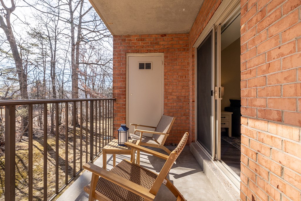 A balcony with a chair and table at Liberty Gardens Apartments, Baltimore, Maryland