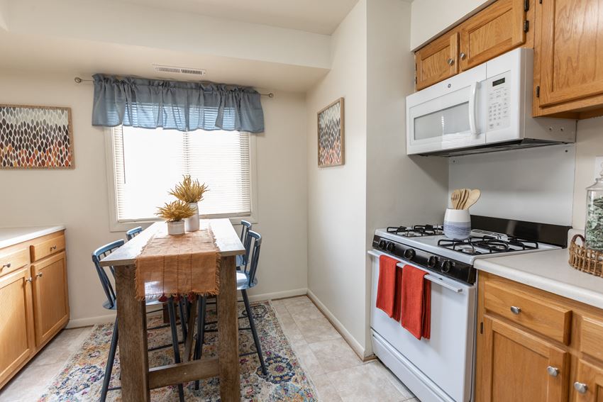 a kitchen with a table and chairs in front of a window