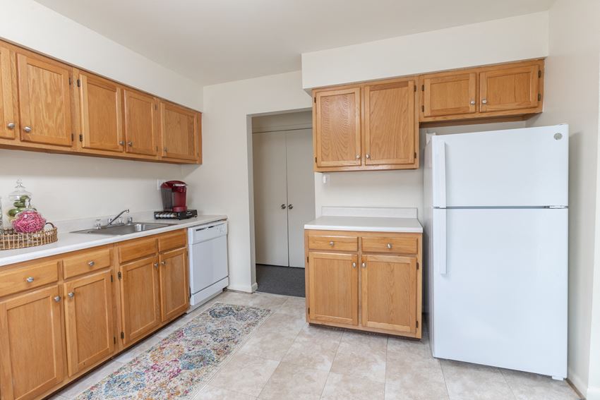 a kitchen with white appliances and wooden cabinets