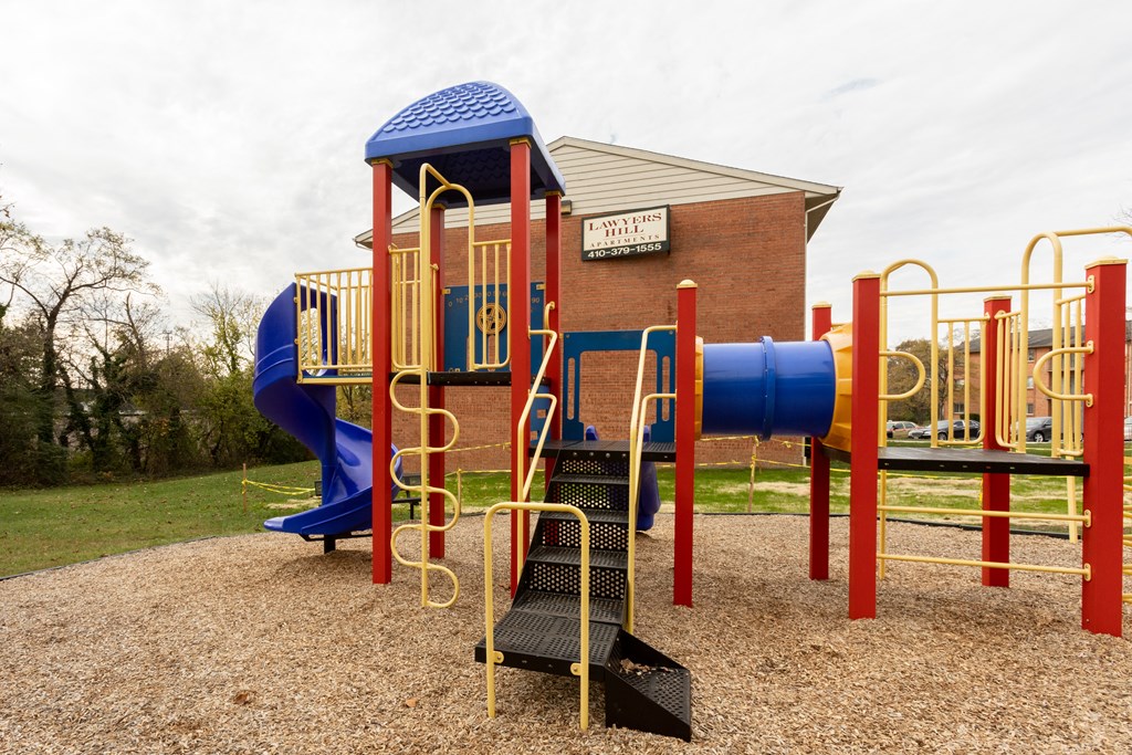 a playground with a blue and red slide and monkey bars at Lawyers Hill Apartments, Elkridge, MD, 21075