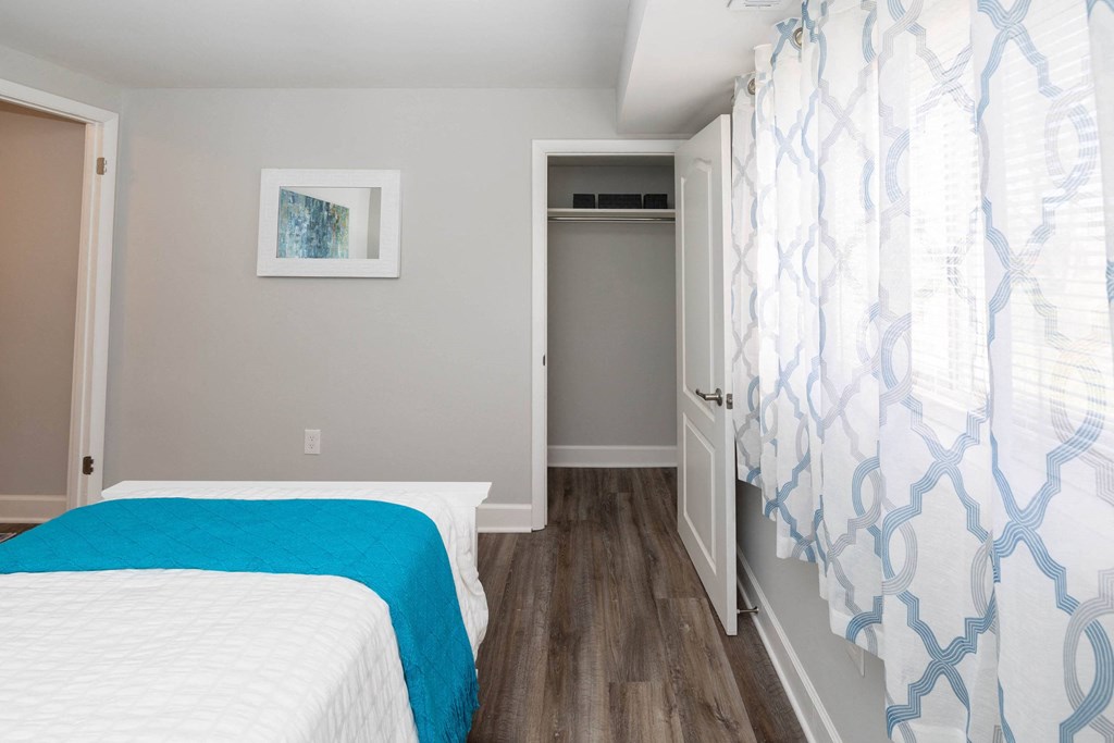 a bedroom with gray walls and a white and blue bedspread at Fairbrook Park, Baltimore, MD