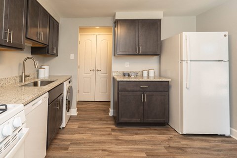 a kitchen with white appliances and brown cabinets