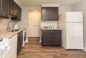 Kitchen with white appliances and brown cabinets at Fairbrook Park, Baltimore, MD 21244