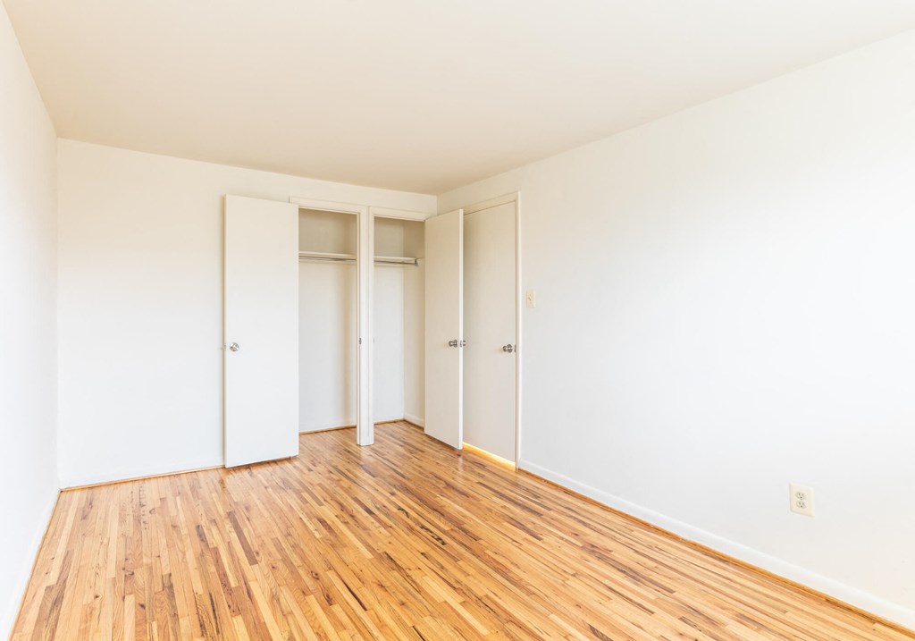 Empty bedroom with white walls and wooden floors at Foxridge Townhomes, Baltimore, 21221