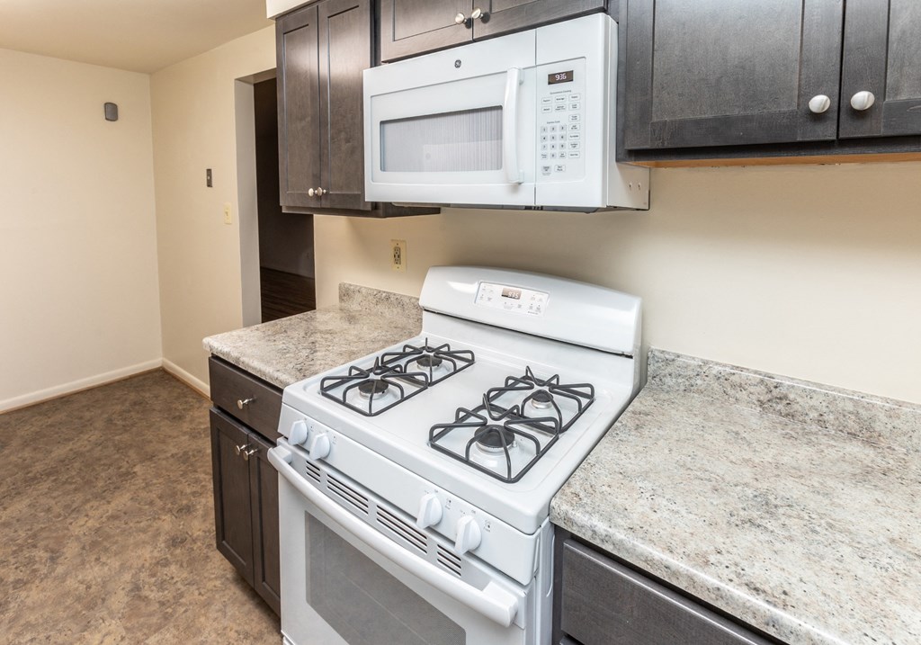 A kitchen with a stove and microwave at Foxridge Townhomes, Baltimore, MD