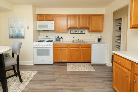 A kitchen with wooden cabinets and a white fridge.