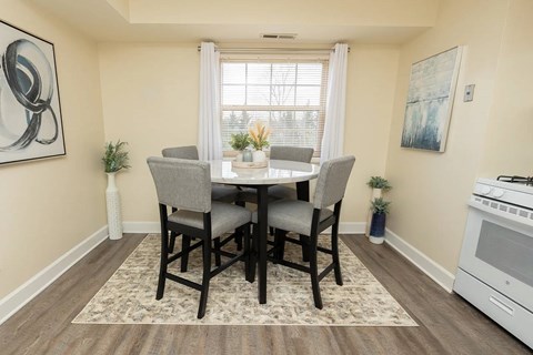 A dining room with a table set for four.