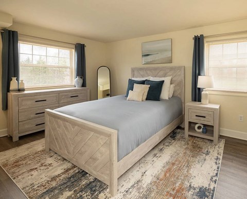 A bedroom with a large bed, nightstands, and a rug.