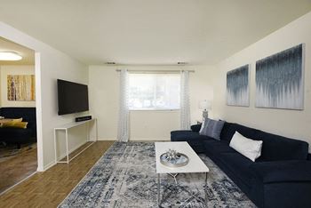 a living room with a navy blue couch and a white coffee table at Winston Apartments, Maryland, 21239
