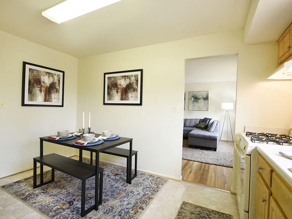 a living room with a dining table and a kitchen with a couch at Arbuta Arms Apartments*, Maryland