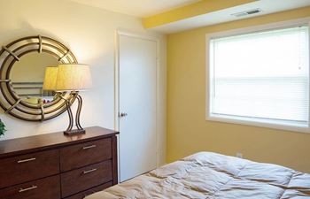 Bedroom with a bed and a dresser and a window at Security Park Apartments*, Maryland