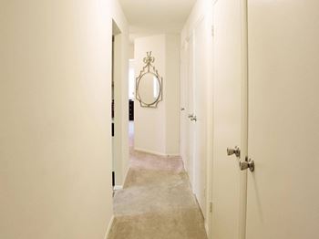 Hallway with a carpeted floor and a mirror on the wall at Security Park Apartments*, Windsor Mill