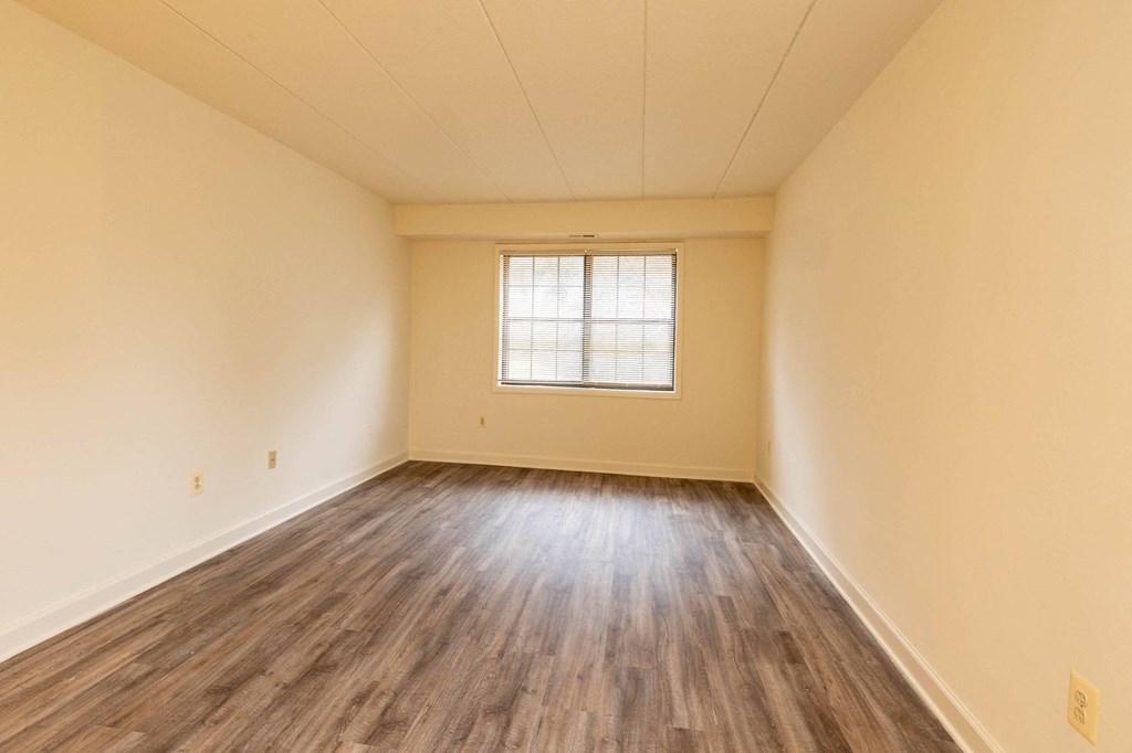 Bedroom with hardwood floors and yellow walls at Ivy Hall Apartments*, Towson, MD 21204