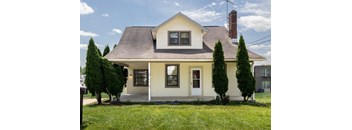 a house with a lawn and trees in front of it at Ivy Hall Apartments*, Towson Maryland