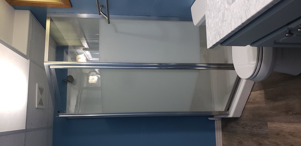 a small bathroom with a toilet and a sliding glass door