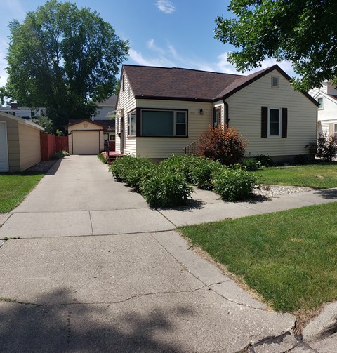 a white house with a sidewalk in front of it