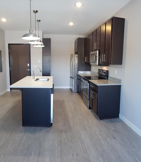 A kitchen with dark brown cabinets and a white island.