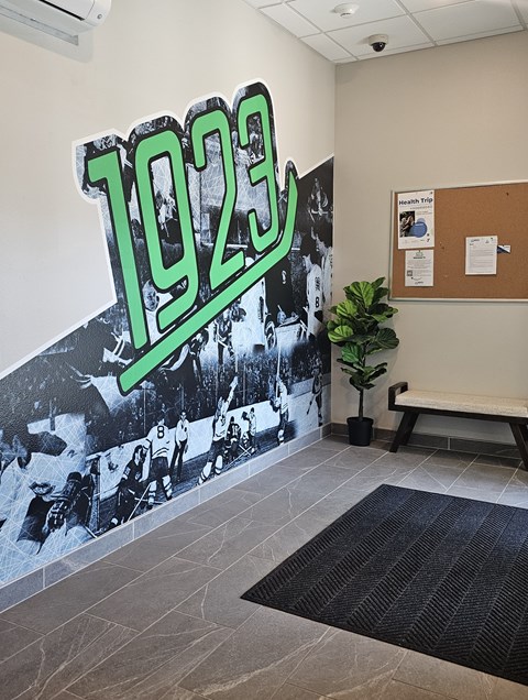 A wall with a 1923 sign and a photo of people playing baseball.