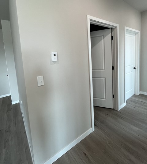 a bedroom with a white wall and a door to a hallway