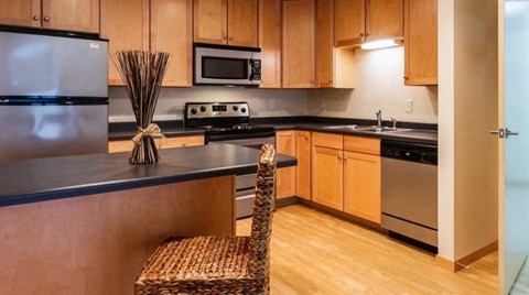 A kitchen with wooden cabinets and a black countertop.