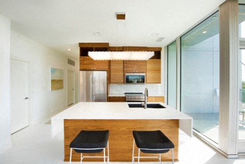 a kitchen with a white counter top and two chairs