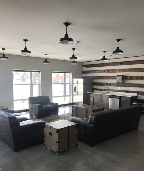 A living room with a black couch and a wooden cabinet.