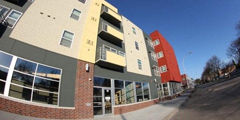 A modern apartment building with a curved design and multiple balconies.