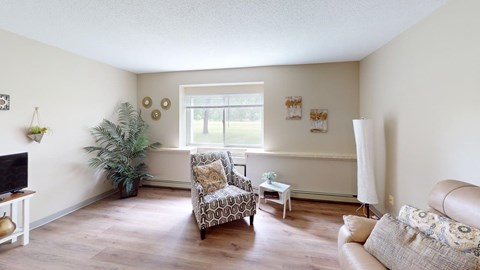 A living room with a couch, chair, and television.