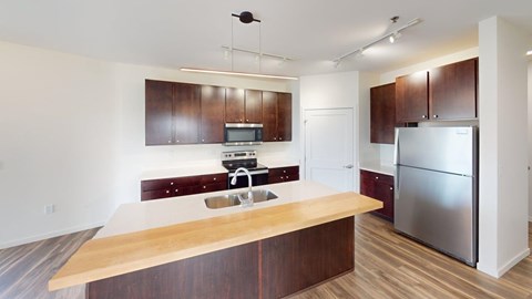 A kitchen with a wooden counter top and stainless steel appliances.
