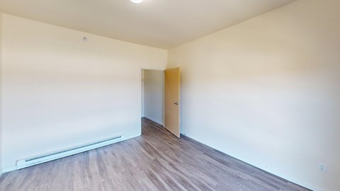 A room with a wooden floor and a door.