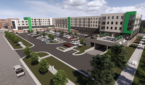 A rendering of a hospital parking lot with a green and white building in the background.