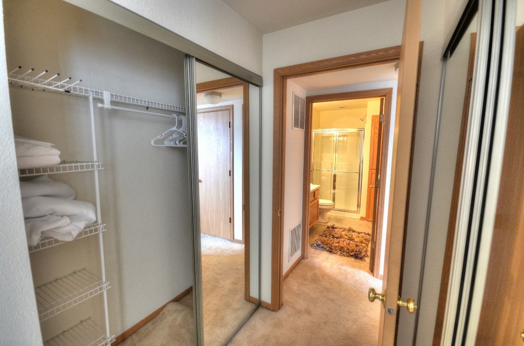 the walk in closet in the master bedroom has a mirrored closet door