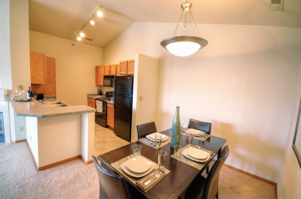 a dining room and kitchen with a table and chairs
