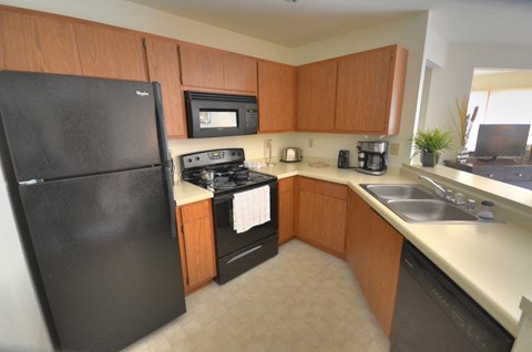 a kitchen with black appliances and wooden cabinets