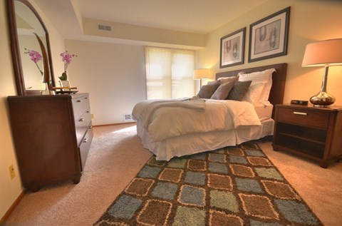 a bedroom with a bed and a dresser and a mirror