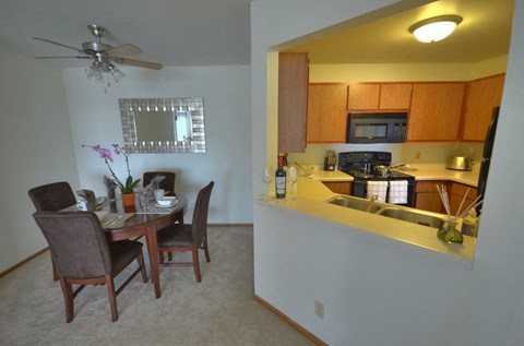 A kitchen with a dining table and chairs.
