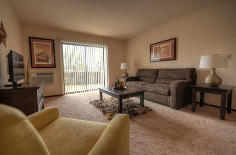 A living room with a yellow couch and a brown couch.