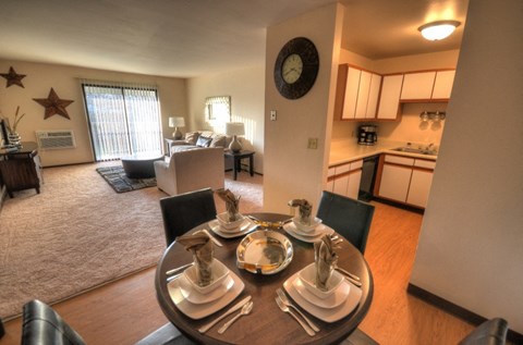 an open living room with a dining room table and a kitchen