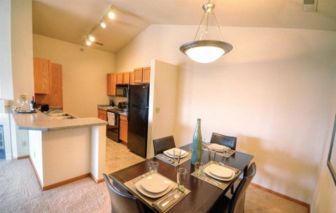 a dining room and kitchen with a table and chairs