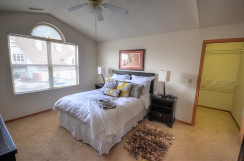 a bedroom with a bed and a ceiling fan