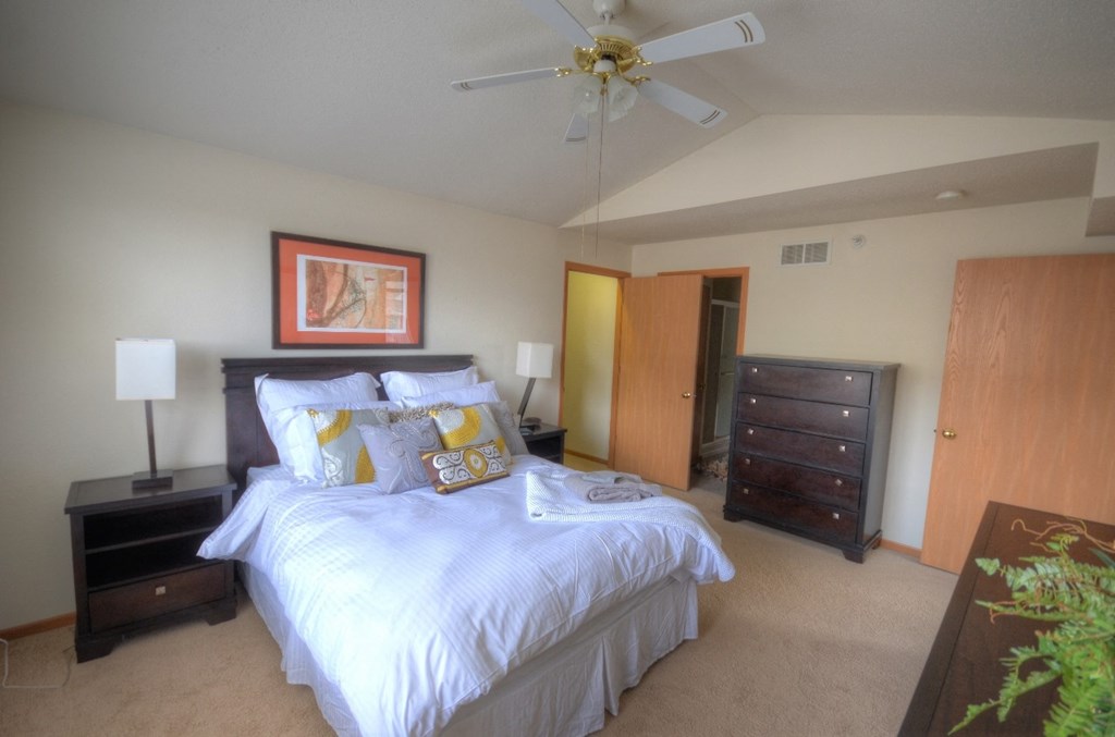 a bedroom with a large bed and a ceiling fan