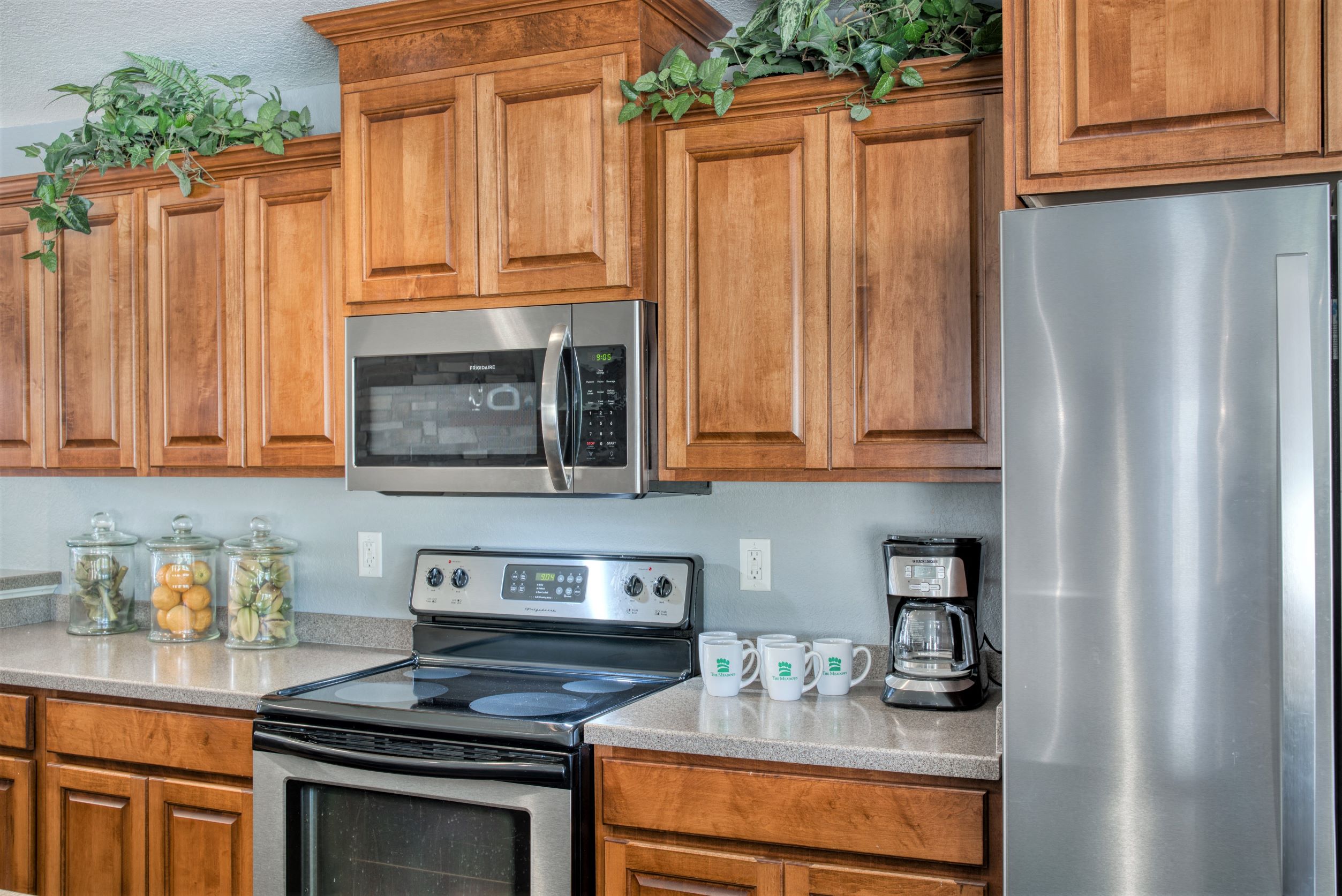 A kitchen with wooden cabinets and a stainless steel refrigerator.