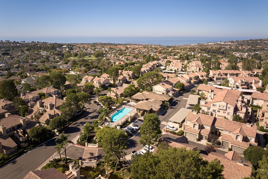 A bird's eye view of a residential neighborhood with houses and a pool at Valentia Apartments in La Jolla.