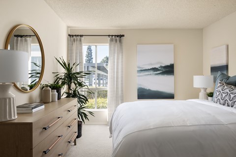 Bedroom featuring a window and wall art at Crystal Springs apartments in Fountain Valley.