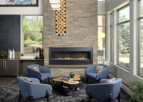 a living room with blue chairs and a fireplace