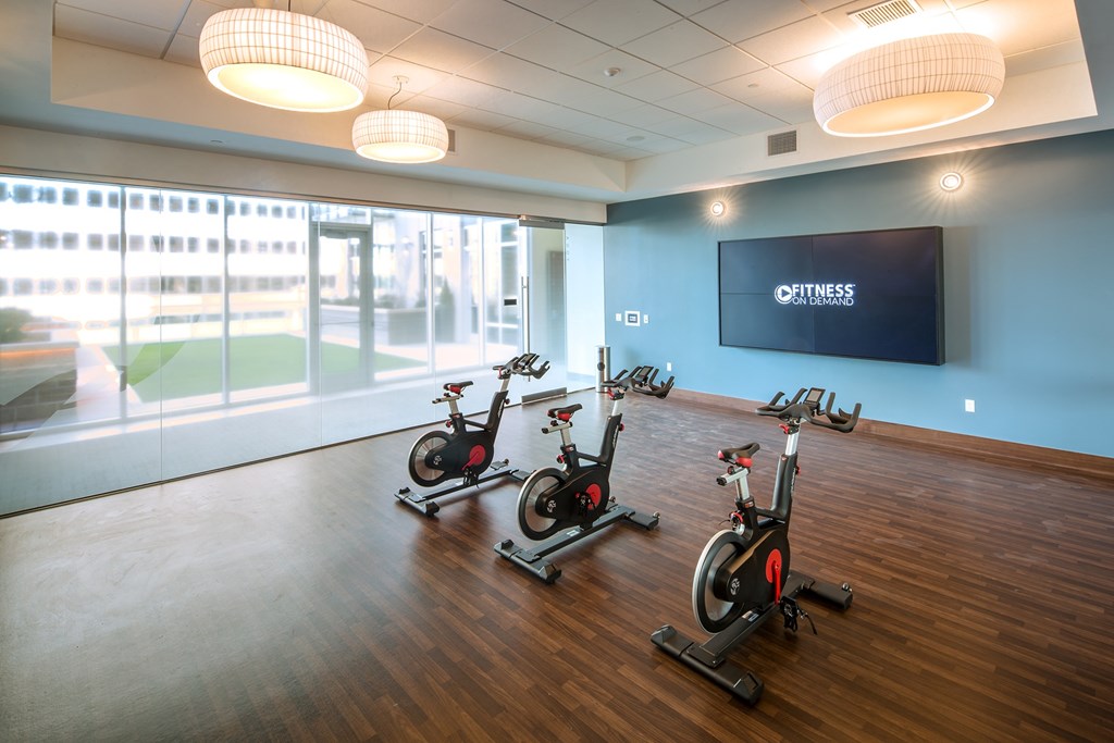 A gym with a row of stationary bikes and a Fitness TV screen.